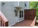 Cozy back porch featuring a wooden deck, white door, and light gray siding on a two-story home at 5029 David Pl, Smyrna, GA 30082