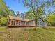A beautiful exterior of home with a chimney, deck with table set, surrounded by lush, green trees and a sunny, blue sky at 1997 N Landing Way, Marietta, GA 30066