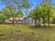 Gray house with trees surrounding it on a grassy lot beneath a blue sky at 1997 N Landing Way, Marietta, GA 30066