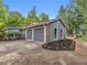 An attached two-car garage with stone accents, surrounded by plants and a long driveway with green trees in the background at 1997 N Landing Way, Marietta, GA 30066