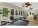 Bright sunroom features workout equipment, tile floor, and walls of windows overlooking wooded yard at 1997 N Landing Way, Marietta, GA 30066