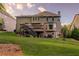 Exterior of the home, displaying a multi-level deck with an outdoor seating area and a spacious, well-manicured lawn at 5028 Winding Hills Ln, Woodstock, GA 30189