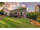 Picture of the back exterior of the home, which features a deck with stairs, and a lush, green yard at 5028 Winding Hills Ln, Woodstock, GA 30189