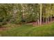 View of a private, wooded backyard with a putting green and mature trees at 5028 Winding Hills Ln, Woodstock, GA 30189