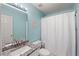 Bright bathroom with white shower curtain, granite countertop, and blue wall at 5028 Winding Hills Ln, Woodstock, GA 30189