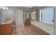 Bathroom features a glass shower, soaking tub, granite vanity, and tile flooring at 5028 Winding Hills Ln, Woodstock, GA 30189