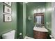 Stylish half bath with dark green walls, wooden vanity, and modern fixtures at 5028 Winding Hills Ln, Woodstock, GA 30189