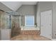Bathroom features a glass shower, soaking tub, and mosaic tile accents at 5028 Winding Hills Ln, Woodstock, GA 30189