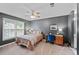 Bedroom featuring a ceiling fan, gray walls, and large windows overlooking the backyard at 5028 Winding Hills Ln, Woodstock, GA 30189