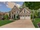 Inviting two-story home with a spacious driveway and well-maintained lawn surrounded by mature trees at 5028 Winding Hills Ln, Woodstock, GA 30189