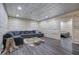 Basement featuring wood-paneled walls, laminate floors, and cozy sectional couch at 527 Cass White Nw Rd, Cartersville, GA 30121