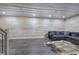 Basement featuring wood-paneled walls, laminate floors, and gray sectional couch at 527 Cass White Nw Rd, Cartersville, GA 30121