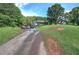 Charming home exterior with a welcoming front porch and long driveway amidst lush greenery at 527 Cass White Nw Rd, Cartersville, GA 30121