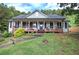 Charming home featuring a welcoming front porch, a well-maintained lawn, and mature trees at 527 Cass White Nw Rd, Cartersville, GA 30121