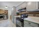 Kitchen boasts grey cabinetry, black appliances, and laundry area with stainless steel units at 527 Cass White Nw Rd, Cartersville, GA 30121