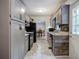 Galley kitchen boasts grey cabinetry, black appliances, and exterior door access at 527 Cass White Nw Rd, Cartersville, GA 30121