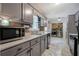 Galley kitchen featuring grey cabinetry, stainless steel appliances, and wood accent wall at 527 Cass White Nw Rd, Cartersville, GA 30121