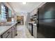 Galley kitchen featuring grey cabinetry, black appliances, and wood accent wall at 527 Cass White Nw Rd, Cartersville, GA 30121