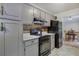 Galley kitchen featuring grey cabinetry, black appliances, and dining room view at 527 Cass White Nw Rd, Cartersville, GA 30121