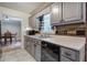 Galley kitchen features grey cabinetry, black appliances, and stainless steel sink at 527 Cass White Nw Rd, Cartersville, GA 30121