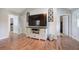 Bright living room area featuring hardwood floors, a large television, and neutral paint at 527 Cass White Nw Rd, Cartersville, GA 30121