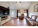 Bright living room featuring hardwood floors, a leather sofa, recliner, and a front door with decorative glass at 527 Cass White Nw Rd, Cartersville, GA 30121