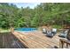 Relaxing deck area with an above ground pool, outdoor seating and natural forest views at 527 Cass White Nw Rd, Cartersville, GA 30121