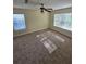A bright bedroom features carpeted floors and two windows letting in natural light, and a ceiling fan at 1202 Santa Fe Pkwy, Atlanta, GA 30350