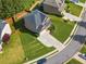 Aerial view of a landscaped property featuring a well-maintained yard, long driveway, and mature trees at 1925 Piedmont Cove Ln, Cumming, GA 30040