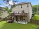 The home's backyard features a large deck with steps down to a patio and a grassy yard surrounded by a wooden fence at 1925 Piedmont Cove Ln, Cumming, GA 30040