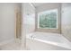 Bathroom featuring white tiled floors and a large soaking tub with separate walk-in shower at 1925 Piedmont Cove Ln, Cumming, GA 30040