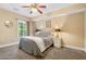 Relaxing bedroom featuring neutral tones, a ceiling fan, and a bright window at 1925 Piedmont Cove Ln, Cumming, GA 30040