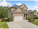 Attractive two-story home with a brick facade, well-maintained lawn, and large driveway at 1925 Piedmont Cove Ln, Cumming, GA 30040