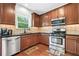 Modern kitchen features stainless steel appliances, wood cabinets, granite countertops and a window view at 1925 Piedmont Cove Ln, Cumming, GA 30040