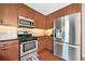 Modern kitchen features stainless steel appliances, wood cabinets, granite countertops at 1925 Piedmont Cove Ln, Cumming, GA 30040