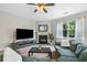 Spacious living room with plush sofa, fireplace, large tv and a view to the backyard at 1925 Piedmont Cove Ln, Cumming, GA 30040