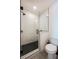 Bathroom featuring a glass-enclosed shower with black and white tiling and white fixtures at 417 E College Ave # 102, Decatur, GA 30030