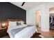 Inviting bedroom features a decorative accent wall, wood furniture, and ensuite bathroom access at 417 E College Ave # 102, Decatur, GA 30030