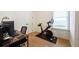 Well-lit home office space featuring a desk, chair, and exercise bike near the window at 417 E College Ave # 102, Decatur, GA 30030