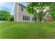 Lush backyard with mature trees and a view of the home's rear facade and patio area at 5281 Tormeall Trce, Suwanee, GA 30024
