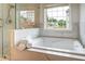 Modern bathroom with a walk-in glass shower and a large soaking tub under a bright window at 5281 Tormeall Trce, Suwanee, GA 30024