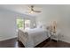 Comfortable bedroom with a ceiling fan, neutral tones, a large window, and hardwood floors at 5281 Tormeall Trce, Suwanee, GA 30024