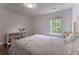 Cozy bedroom featuring a floral comforter, natural light, and a white bookshelf with toys and books at 5281 Tormeall Trce, Suwanee, GA 30024