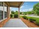 Covered front porch with brick pillars and manicured landscaping at 5281 Tormeall Trce, Suwanee, GA 30024