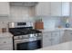 Close up on the gas range and white backsplash in the modern kitchen at 5281 Tormeall Trce, Suwanee, GA 30024