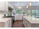 Modern kitchen featuring white cabinets, quartz countertops, stainless steel appliances, and hardwood floors at 5281 Tormeall Trce, Suwanee, GA 30024