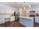 Well-lit kitchen with a large island, stainless steel appliances, and white cabinets at 5281 Tormeall Trce, Suwanee, GA 30024