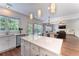 Open concept kitchen with an island, white cabinets, stainless steel appliances, and hardwood floors at 5281 Tormeall Trce, Suwanee, GA 30024