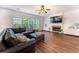 Living room with hardwood floors, a fireplace, a fan and a comfortable sofa at 5281 Tormeall Trce, Suwanee, GA 30024