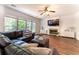 Bright living room with hardwood floors, fireplace, comfortable seating, and a large windows overlooking the yard at 5281 Tormeall Trce, Suwanee, GA 30024
